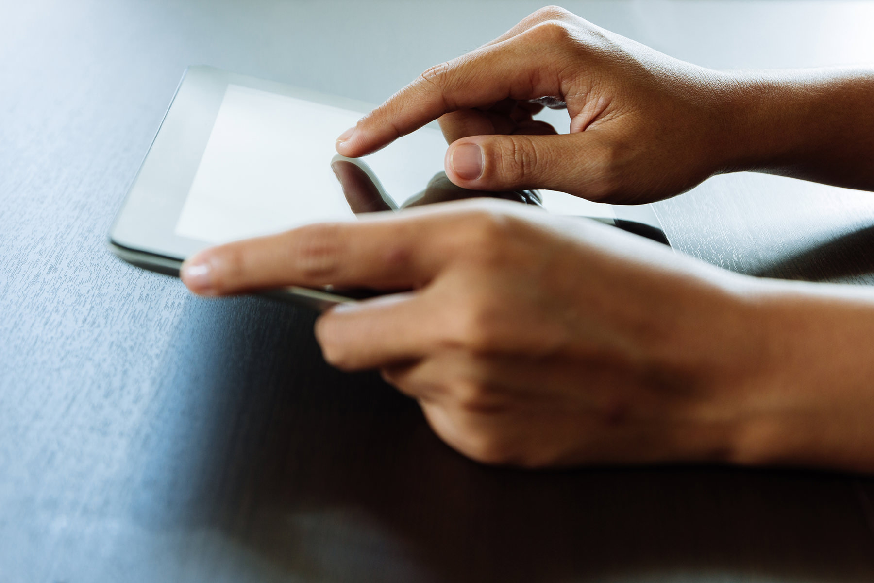 close up of hands using a tablet